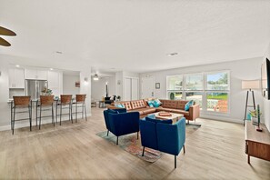Relax in this stylish living area with a large sectional sofa, coffee table, and dining area.
