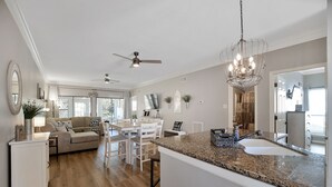 A spacious kitchen with a granite countertop, white cabinetry, and a chandelier. - Upscale Escape on Lake Conroe in April Sound! “On Lake Time” 3-2 on First Floor! (Montgomery)