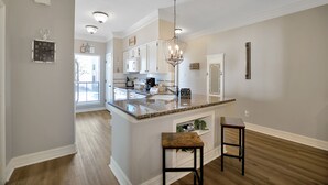 A modern kitchen with a central island, white cabinetry, and a chandelier. - Upscale Escape on Lake Conroe in April Sound! “On Lake Time” 3-2 on First Floor! (Montgomery)