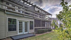 A two-story house with a covered porch and a screened-in area. - Upscale Escape on Lake Conroe in April Sound! “On Lake Time” 3-2 on First Floor! (Montgomery)