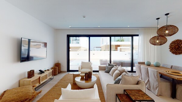 A modern living room with a sofa, coffee table, and a TV mounted on the wall.