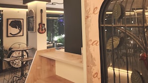 A modern interior with a wooden counter, a clock, and a guitar on the wall. - L'opera Deluxe Hotel (Edremit)
