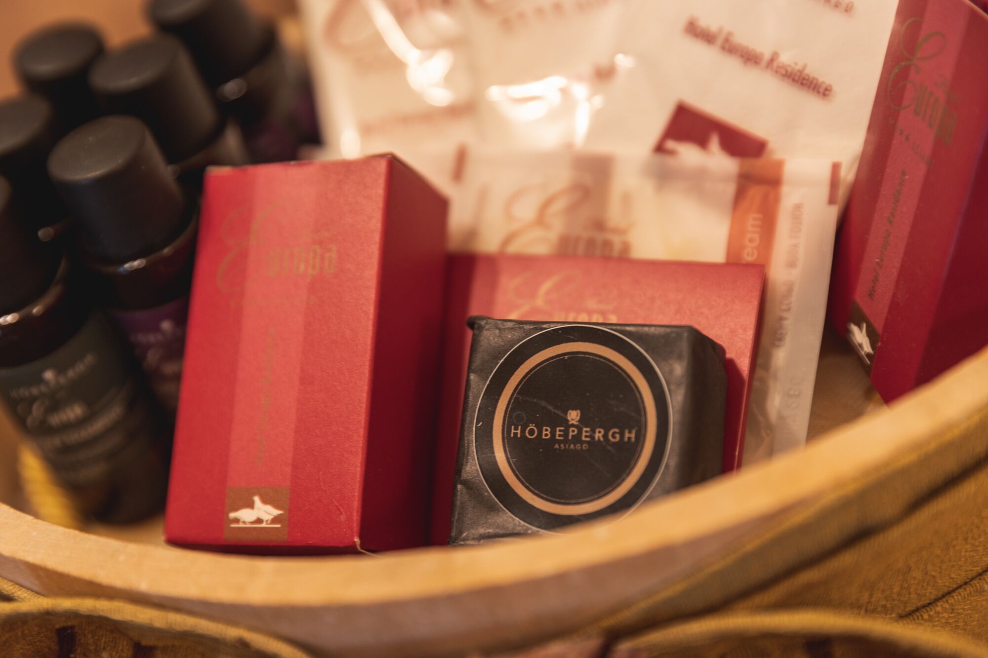 Un panier contenant divers objets, notamment une boîte noire portant l’inscription « Höbergh » et plusieurs boîtes rouges.