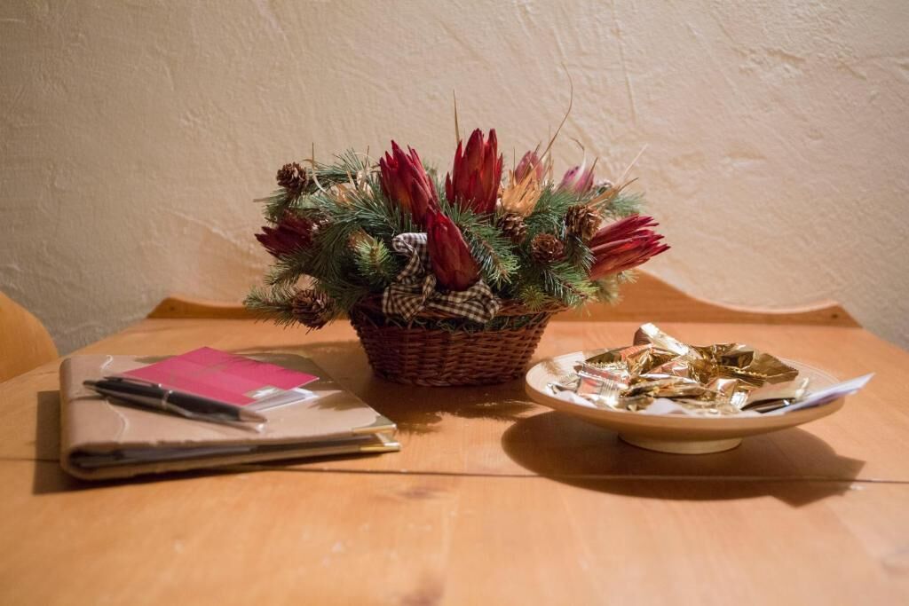 A table with a wicker basket containing a plant, a notebook, and a plate with foil-wrapped items.