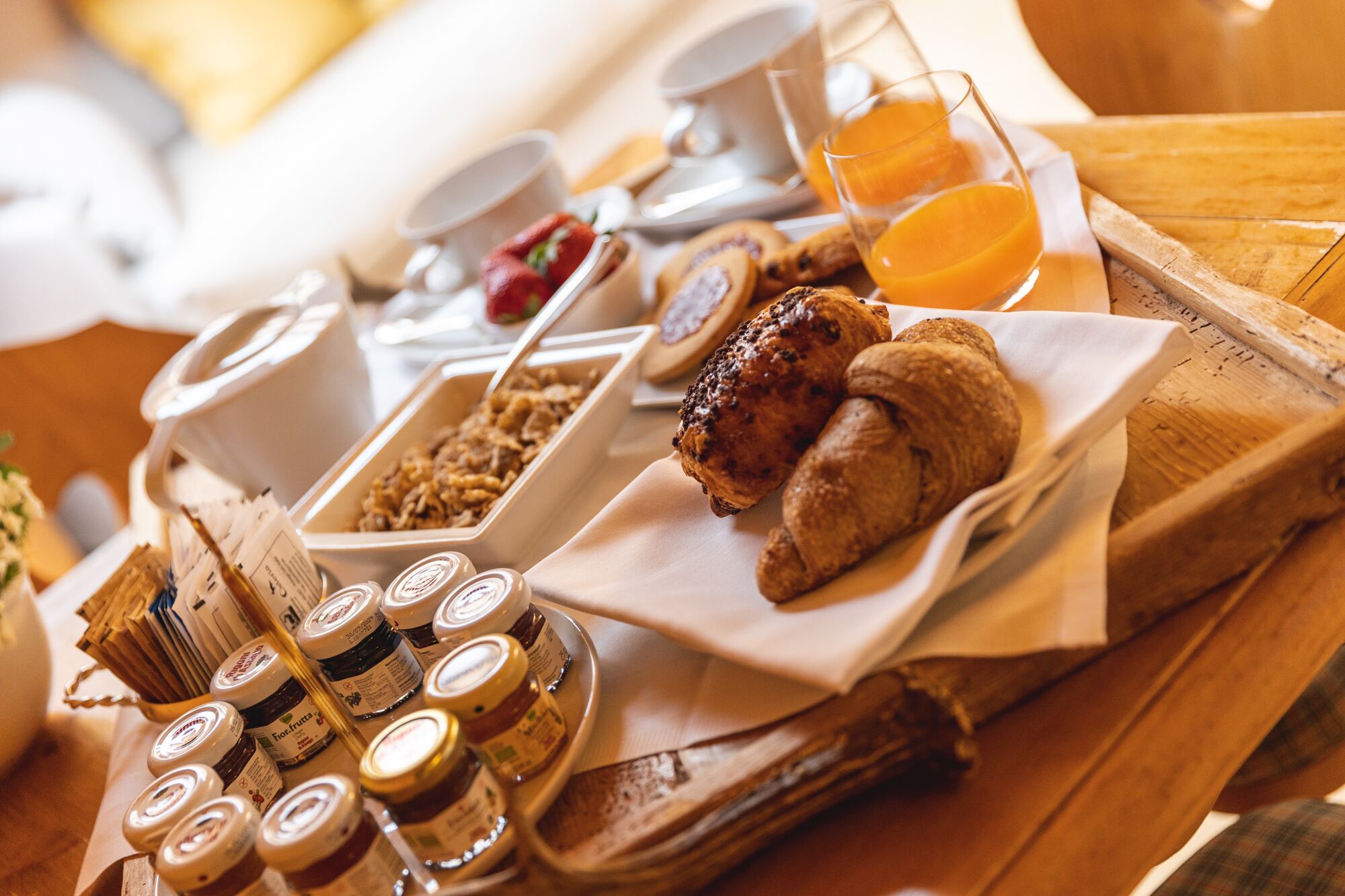 A breakfast buffet with various food items, including pastries, fruits, and condiments.