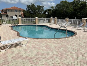 A swimming pool with a brick deck, surrounded by a white fence and lounge chairs. - Tradewinds DEEP WATER 4Br3.5Ba Kayaks/Pr. Dock (Homosassa)