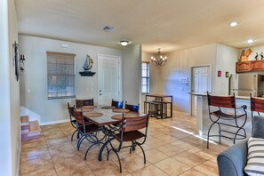A spacious living area with a dining table, chairs, and a kitchen area with a refrigerator and bar stools. - Tradewinds DEEP WATER 4Br3.5Ba Kayaks/Pr. Dock (Homosassa)