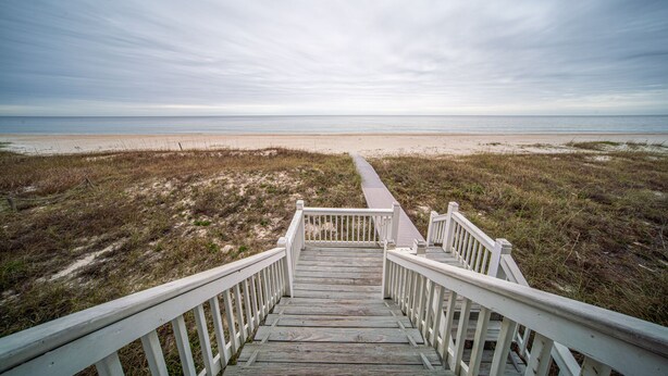 A wooden staircase leading to a beach with a clear view of the ocean. - BEACHFRONT, 5BR/5BA, Sleeps up to 12 w/ Elevator & Pool! (St. George Island)