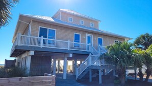 A two-story house with a balcony and a covered porch. - BEACHFRONT, 5BR/5BA, Sleeps up to 12 w/ Elevator & Pool! (St. George Island)