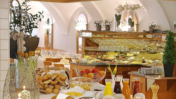 A buffet setup with various food items, a candle, and a salt and pepper shaker on a table.