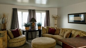 A living room with a sofa, ottoman, and a lamp on a table. - Beautiful Home in South Park. Walk to UD Campus, Miami Valley Hospital, Downtown (Dayton)