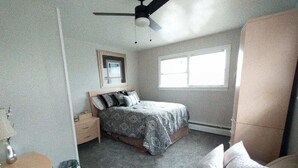 A bedroom with a bed, a nightstand, a dresser, a window, and a ceiling fan. - Beautiful Home in South Park. Walk to UD Campus, Miami Valley Hospital, Downtown (Dayton)