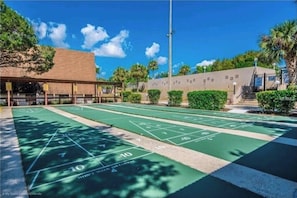 Una cancha de paletas con un edificio al fondo.