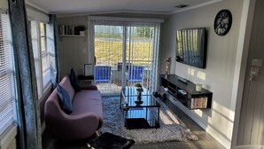 A living room with a sofa, a coffee table, a TV, and a bookshelf.