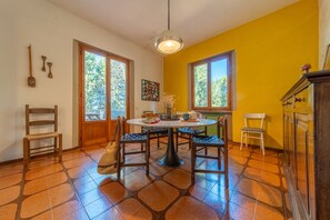 Un comedor con una mesa redonda, sillas y una lámpara colgante.