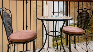 A wooden deck with two metal chairs and a small table. - Vienna Residence, City Hall - Parliament #6414 (Vienna)