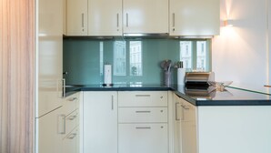 A modern kitchen with white cabinets, a black countertop, and a stainless steel range hood. - Vienna Residence, City Hall - Parliament #6415 (Vienna)