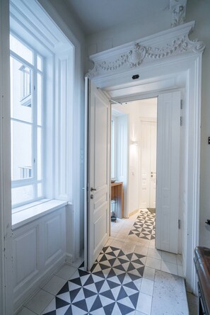 Enter a stylish hallway leading to a room with a door featuring a light switch.