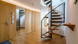 A modern interior with a spiral staircase, wooden flooring, and a mirrored wardrobe. - Vienna Residence, City Hall - Parliament #6420 (Vienna)