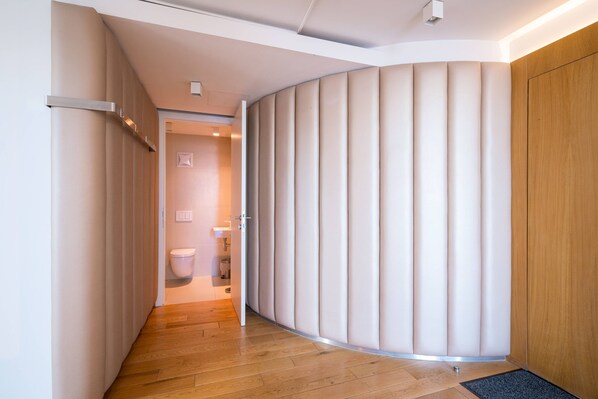 A modern hallway with a curved wall, a wooden floor, and a door leading to a bathroom. - Vienna Residence, City Hall - Parliament #6420 (Vienna)