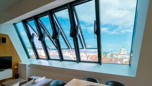 A modern room with a large window, a wooden table, a sofa, and a television. - Vienna Residence, City Hall - Parliament #6420 (Vienna)