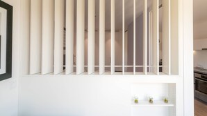 Una cuina moderna amb armaris blancs i forn integrat.