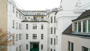 A multi-story building with a central entrance, balconies, and a narrow street between the buildings. - Vienna Residence, City Park - Belvedere #2535 (Vienna)