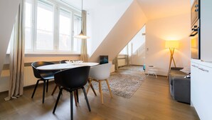 A modern loft apartment with a dining area, a sofa, a lamp, and a TV. - Vienna Residence, City Park - Belvedere #2534 (Vienna)