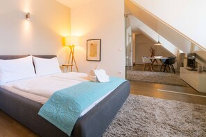 A modern hotel room with a large bed, a desk, and a staircase leading to an upper level. - Vienna Residence, City Park - Belvedere #2534 (Vienna)