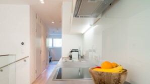 A modern kitchen with a built-in dishwasher, a stainless steel sink, and a wooden bowl of fruit on the counter. - Vienna Residence, Hietzing - Schönbrunn #6362 (Vienna)