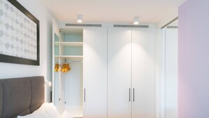 Ein modernes Schlafzimmer mit Bett, Kleiderschrank und einer eingebauten Regaleinheit.