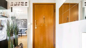 A wooden door with a keyhole and a lock, a mirror reflecting the door, and a hallway with a sofa and decorative items. - CASA MYRIAM with view & private parking  (Μαρούσι)