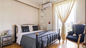 A bedroom with a bed, bedside tables, a chair, and a window with curtains. - CASA MYRIAM with view & private parking  (Μαρούσι)