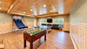 A room with a foosball table, ping pong table, and a basketball hoop. - Grand Peaks Lodge, Luxury Log Home, Views, Hot Tub, Sauna, EV Charger, 3D Tour (Jay)