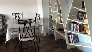 A dining area with a marble table and chairs, a white bookshelf, and a ceiling fan. - Family villa with sea view classified 3*** - 8 people (Le Lavandou)