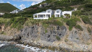 A coastal property with a rocky cliffside and a clear view of the ocean. - Aqua (4 bedrooms) - Ocean view villa with pool, Indigo Bay, St. Maarten (Indigo Bay)