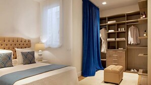 A bedroom with a large bed, a nightstand, a wardrobe, and a window with curtains.