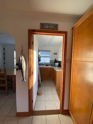 A kitchen with wooden cabinets, a tiled floor, and a window. - The Meadows St Teath, 4 bed sleeps 7 (Saint Teath)