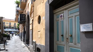 A narrow street with a building featuring a sign for "Royal Blue Suite" and a no parking sign.