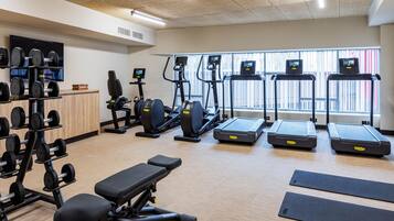 A gym with treadmills, elliptical machines, and weightlifting equipment.
