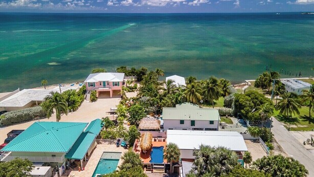 Ett semesterhotell med flera byggnader, en swimmingpool och utsikt över havet.