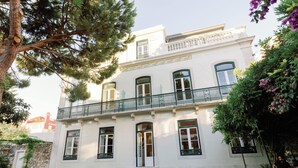 A two-story building with a balcony, a front entrance with steps, and outdoor seating. - Palácio do Visconde (Lisbon)