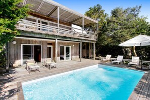 Relax by the pool surrounded by lush greenery and trees.
