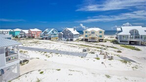 Ein Strandhaus mit bunten Häusern, sandigem Strand und Blick auf den Ozean.