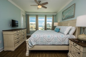 A bedroom with a bed, a dresser, a TV, and a ceiling fan. - Steps to Beach, Views, 6BR, Pools (Gulf Shores)