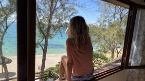 A person sitting by a window overlooking a beach with trees and the sea. - Spacious villa set in the turquoise lagoon of Trou d'eau Douce (Trou d'Eau Douce)