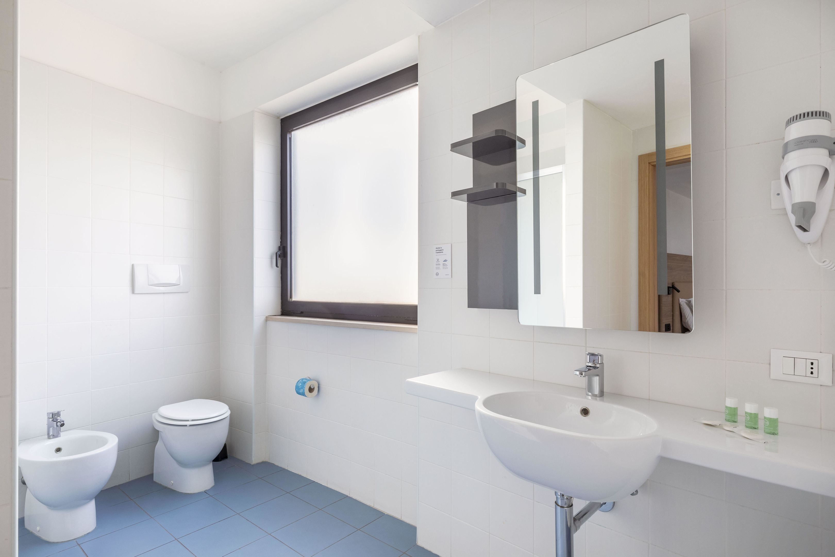 Ein modernes Badezimmer mit einer Bidet-Funktion, Toilette und Waschbecken.