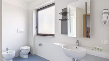 Ein modernes Badezimmer mit einer Bidet-Funktion, Toilette und Waschbecken.