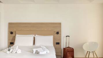 A hotel room with a wooden headboard, a neatly made bed with white linens, a brown suitcase, and a white chair.