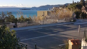 Una carretera costera con vistas despejadas al mar y montañas a lo lejos.